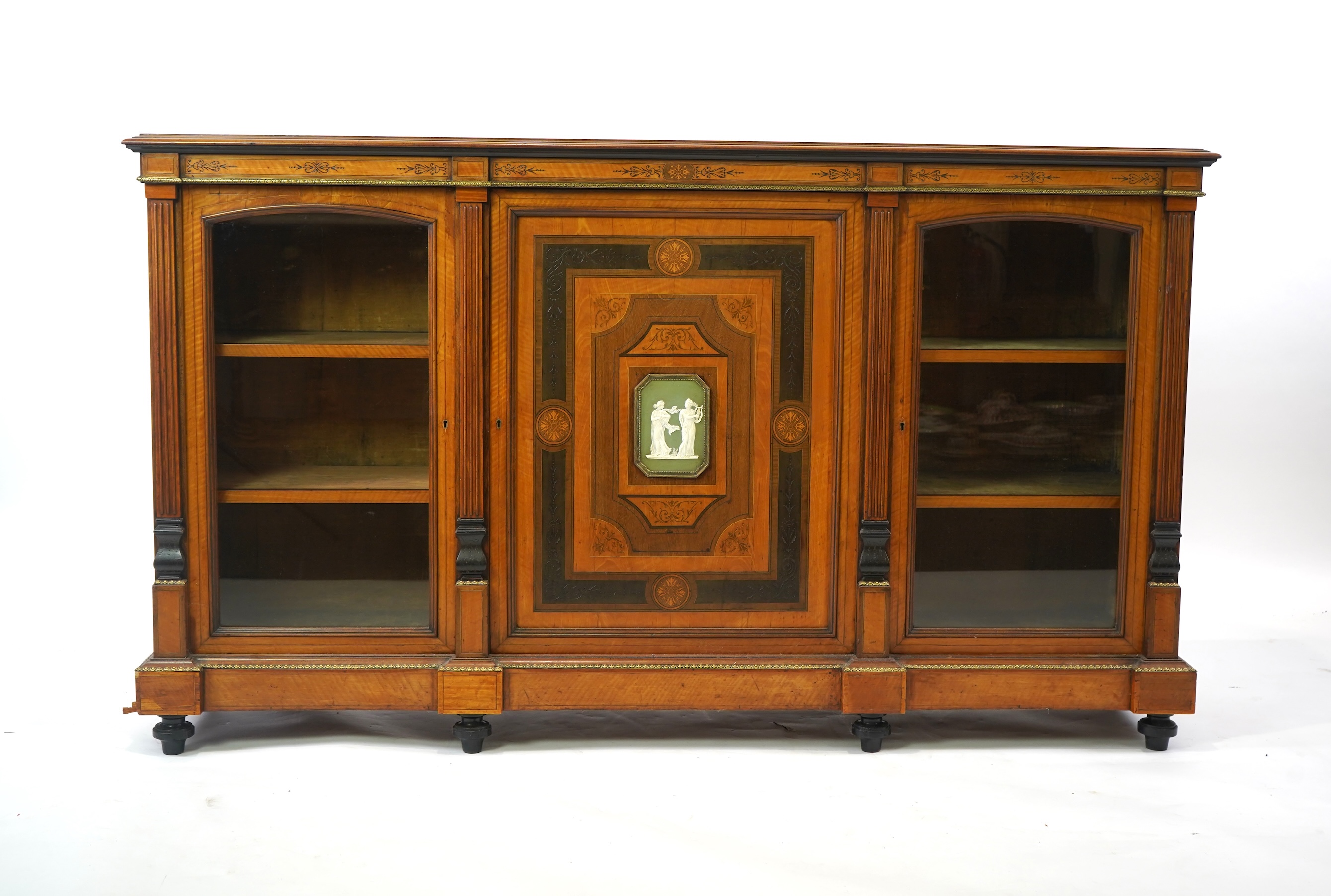 A Victorian marquetry inlaid and gilt metal mounted banded satinwood side cabinet, with anthemion carved frieze over a central door applied octagonal Wedgwood style green and white octagonal jasper plaque, flanked by gla
